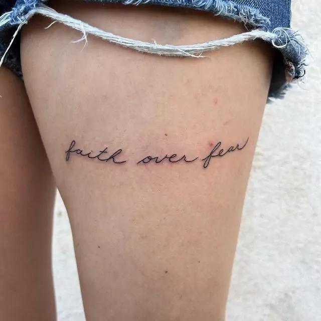 Faith over fear tattoo on the thigh