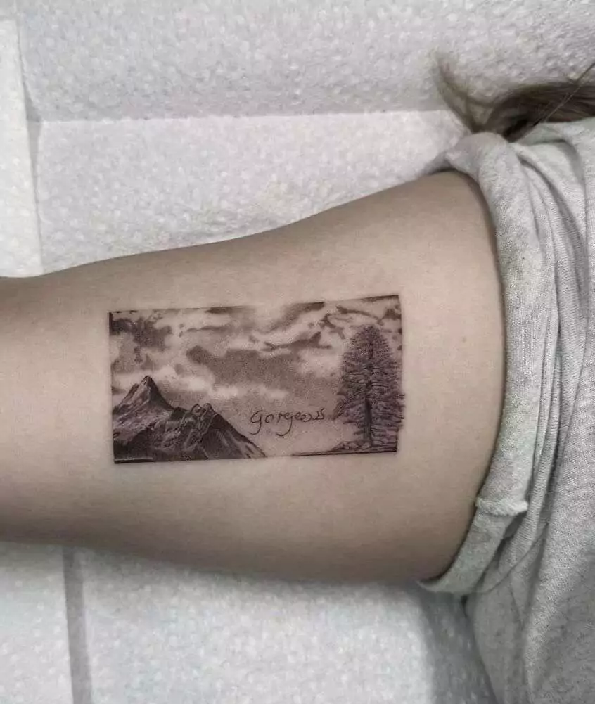 dark frame mountain arm tattoo