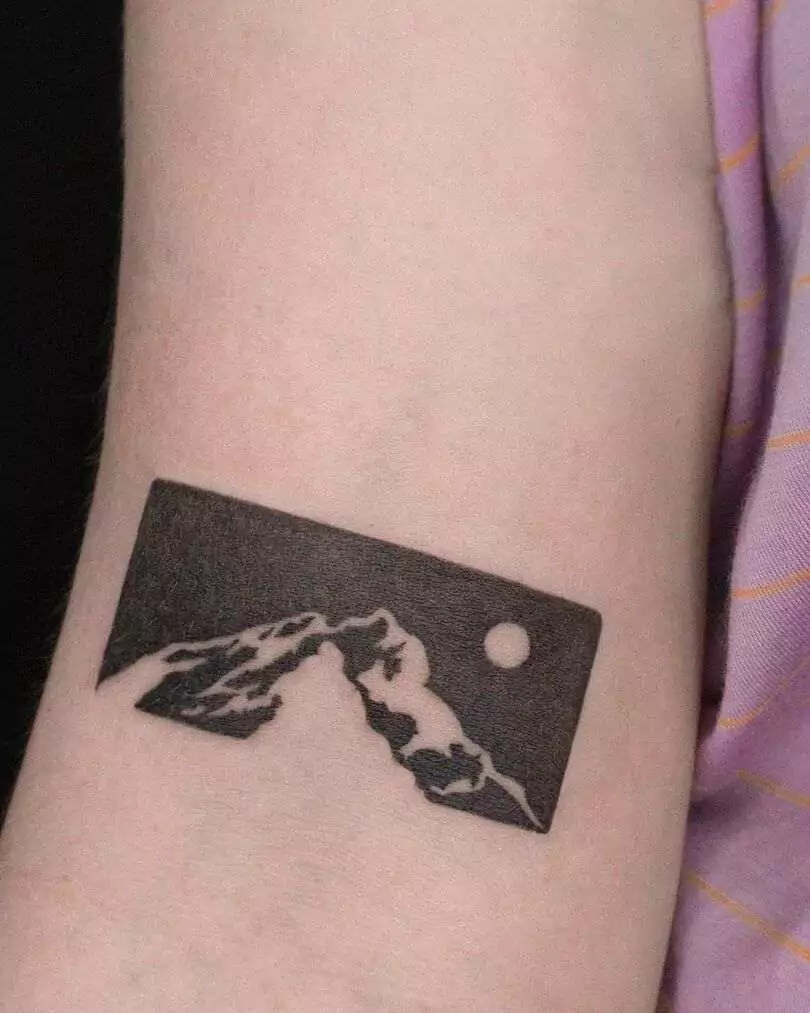 negative style mountain hand tattoo