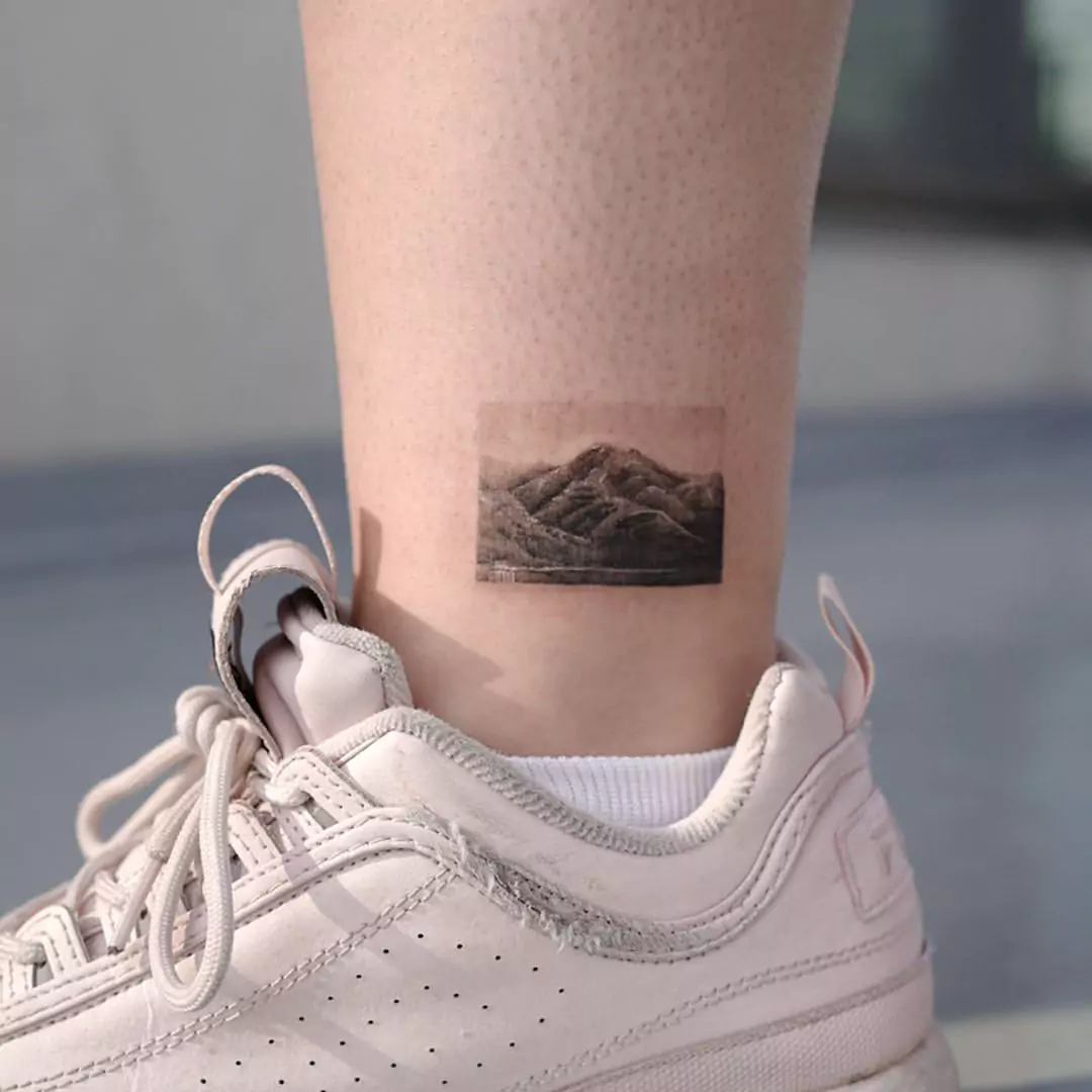 realistic frame mountain leg tattoo