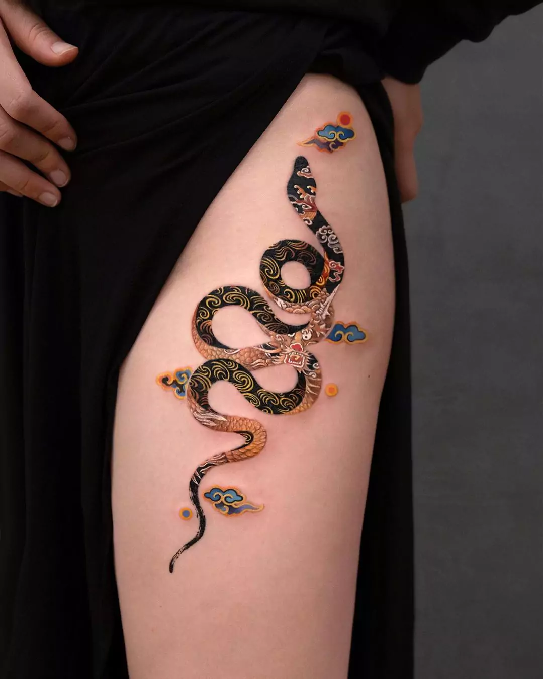 black realistic snake thigh tattoo