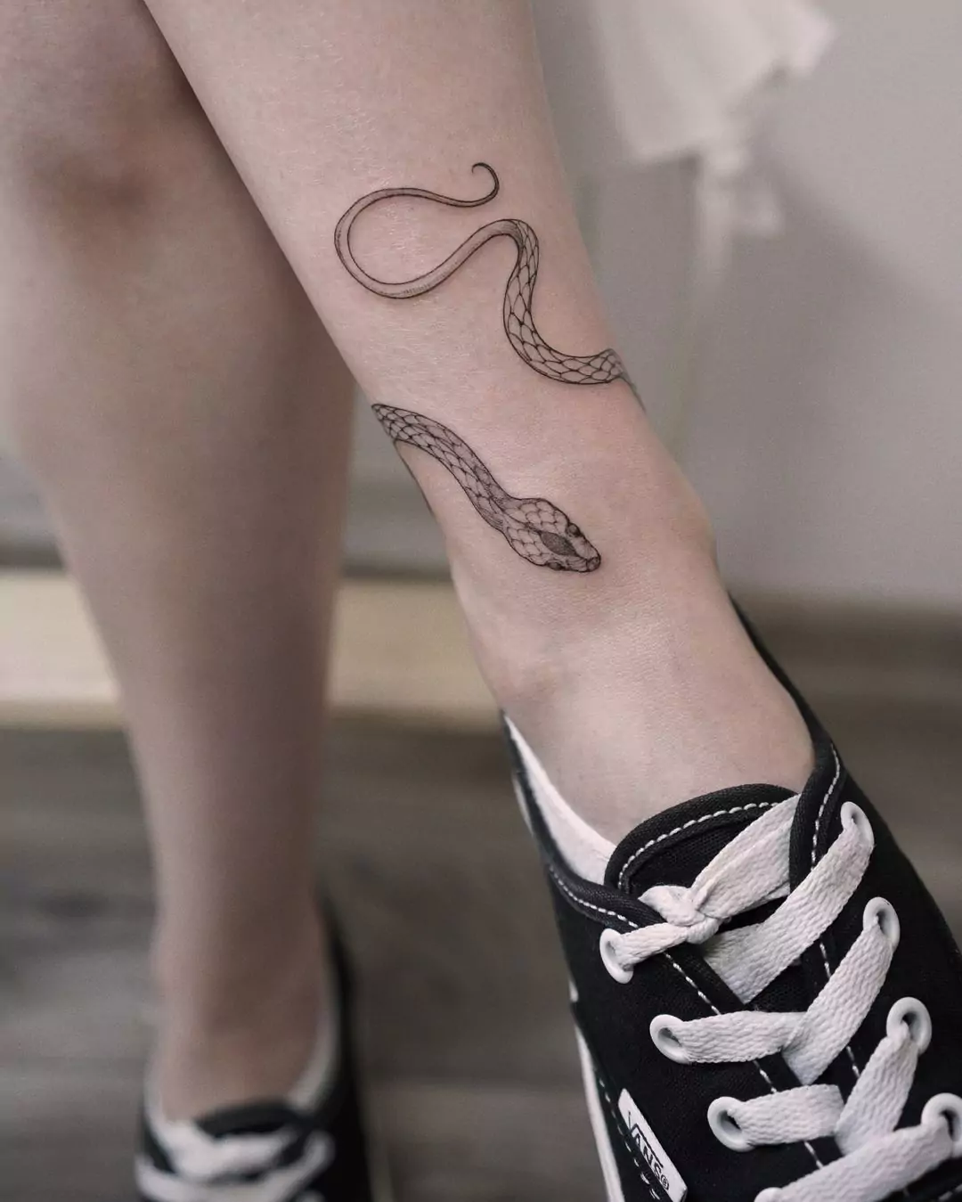 cute curly snake leg tattoo