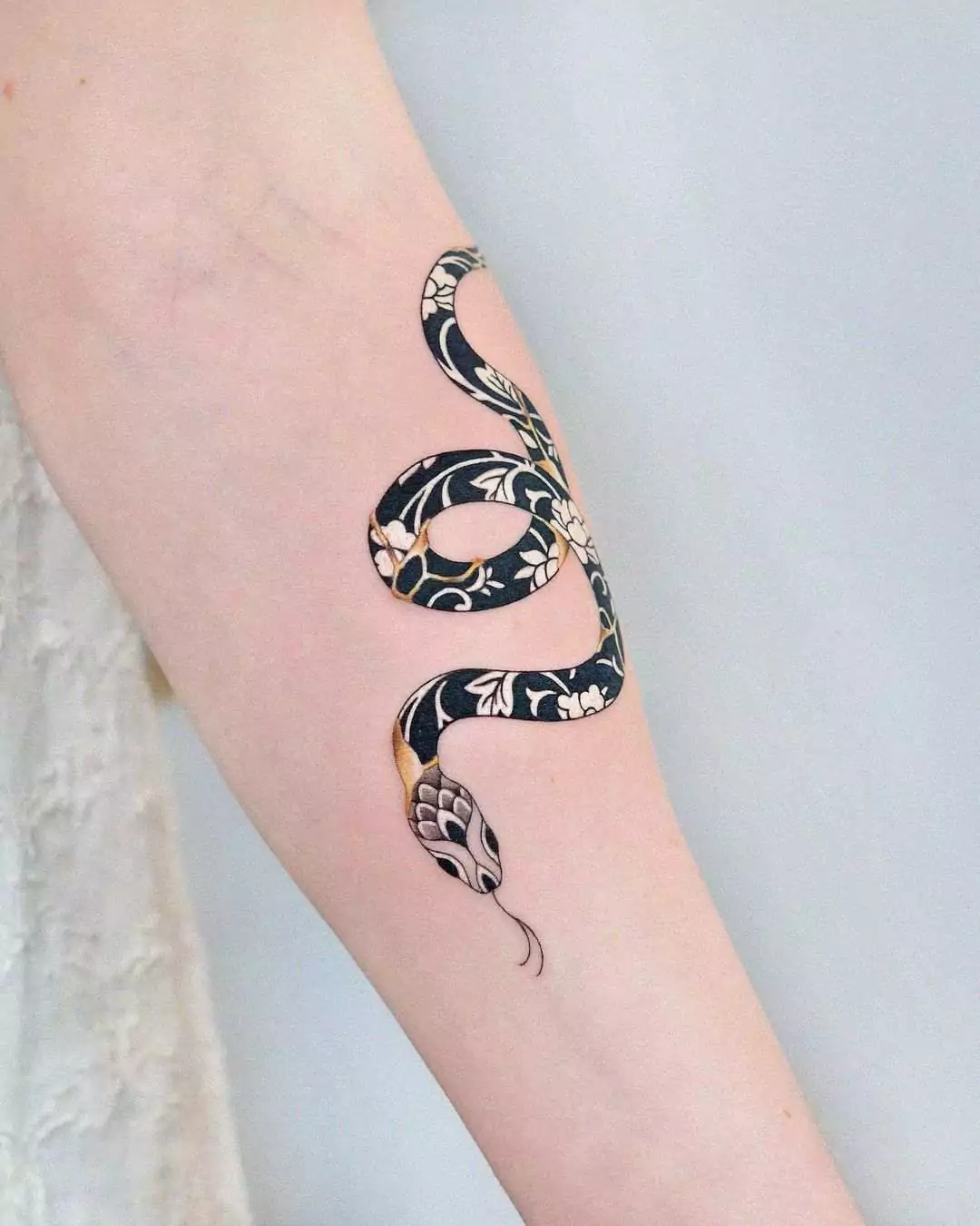 floral snake hand tattoo