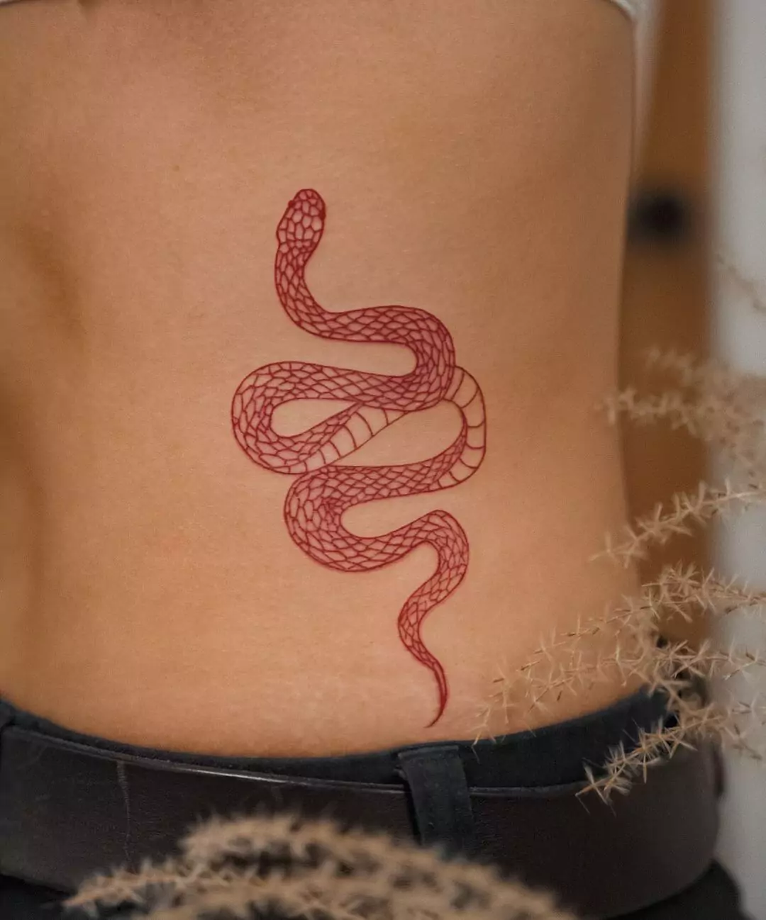 red simple snake hip tattoo