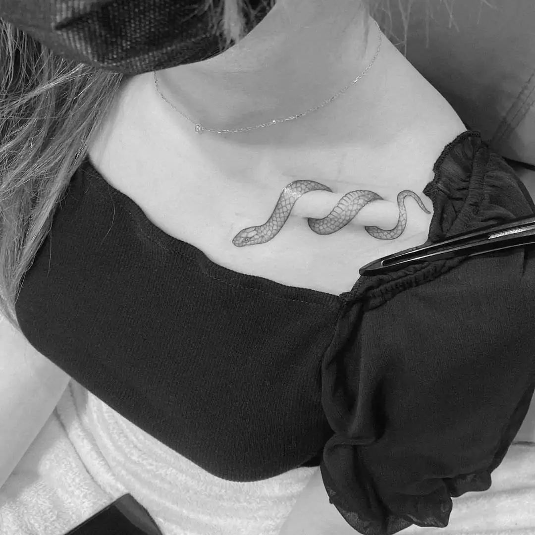 small black snake collarbone tattoo