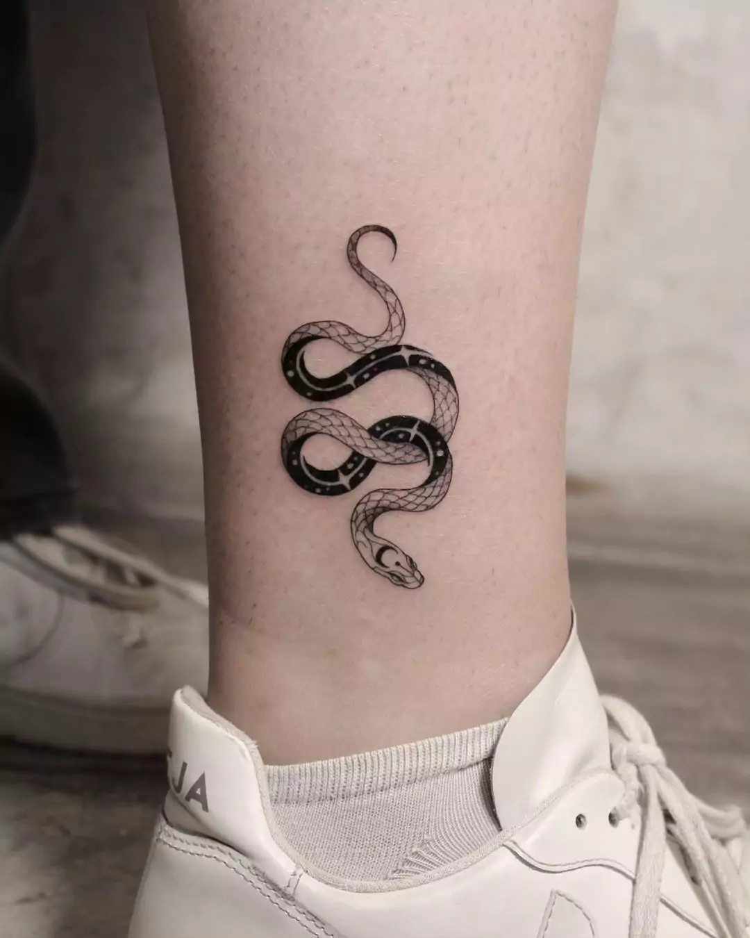 small snake tattoo in cosmic style