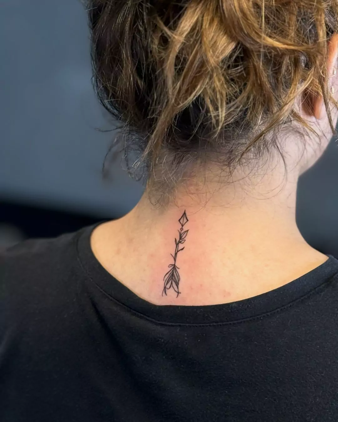 black arrow tattoo on the nape