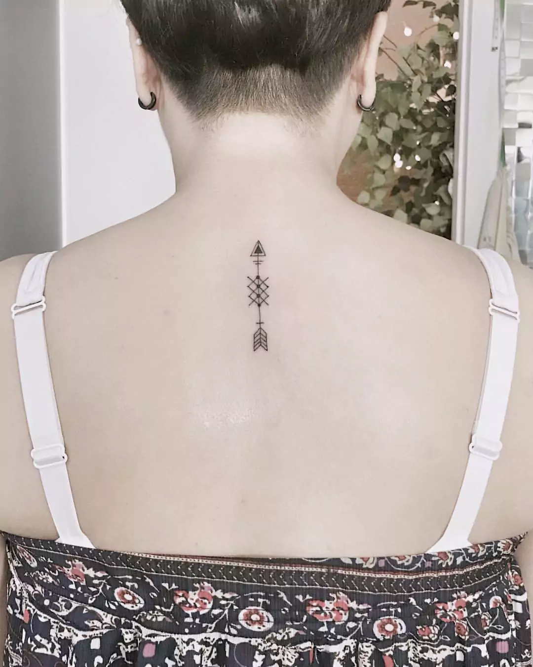 simple arrow nape tattoo for women