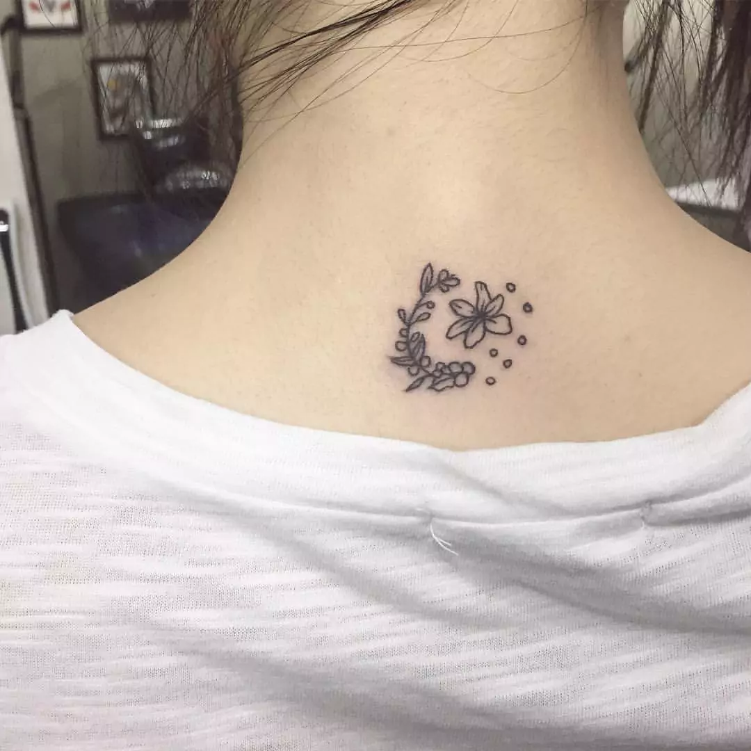 small flower tattoo on the neck