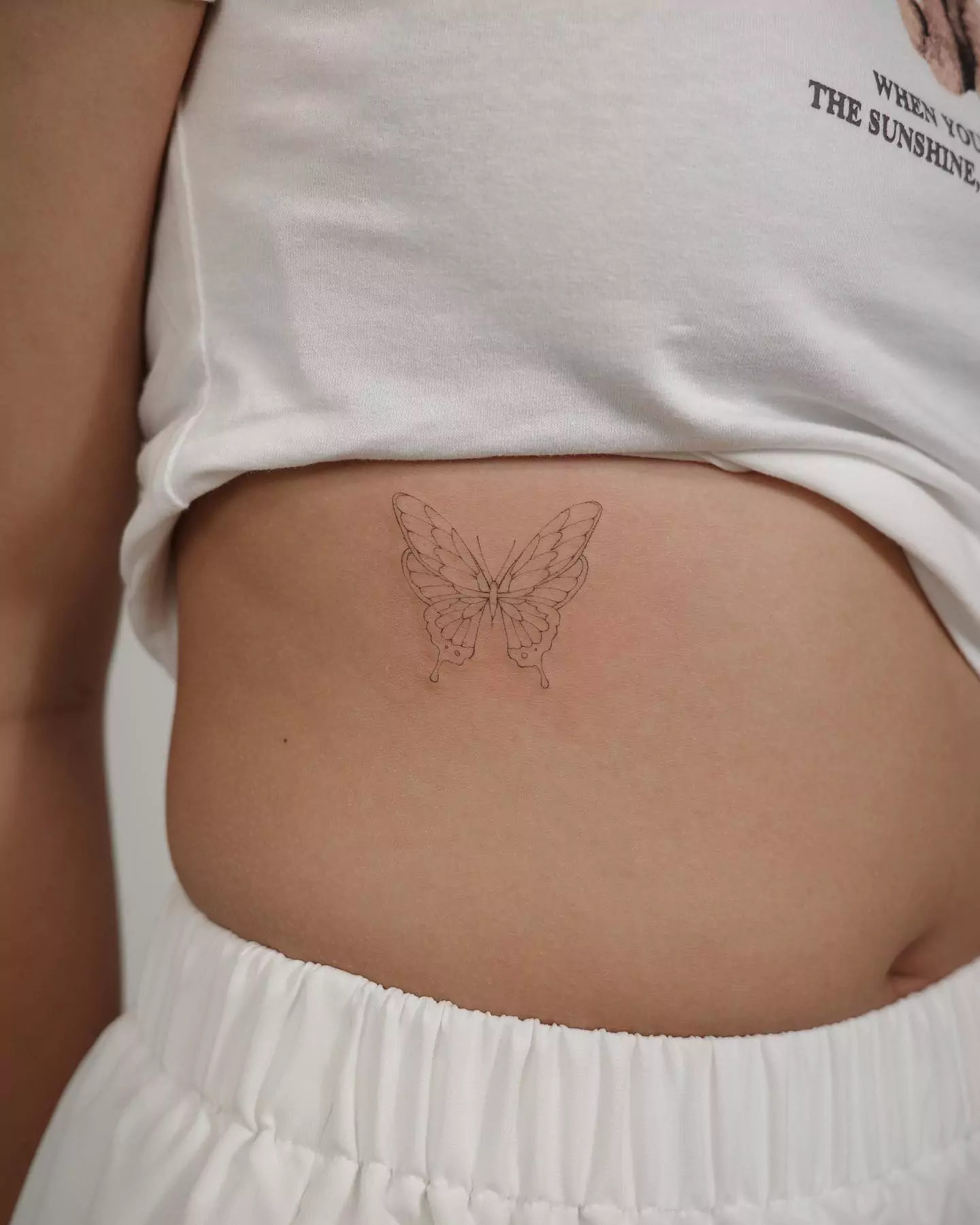 big simple butterfly rib tattoo