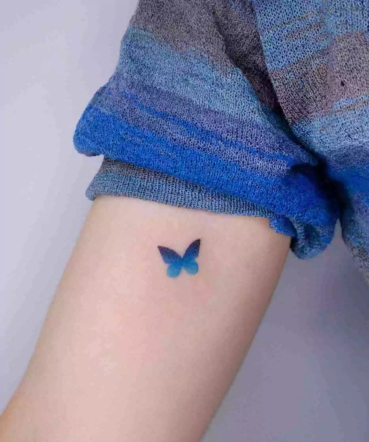 blue and black butterfly hand tattoo