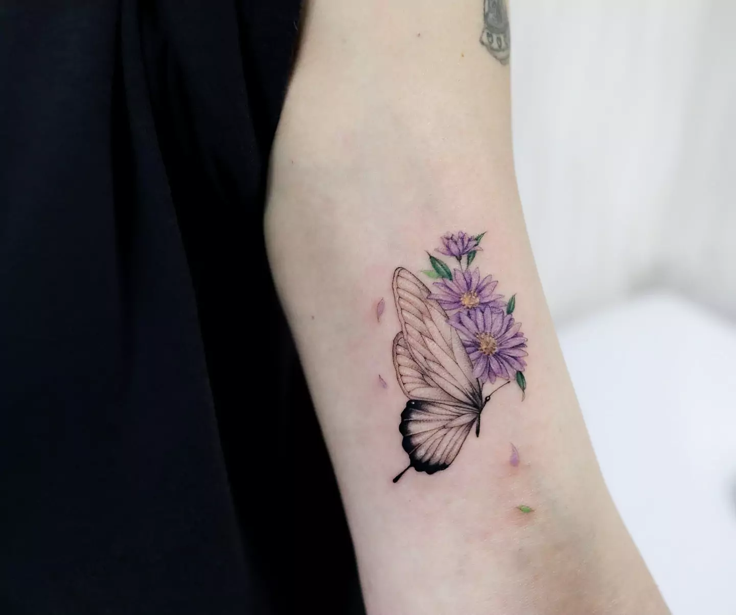 butterfly and small flower hand tattoo