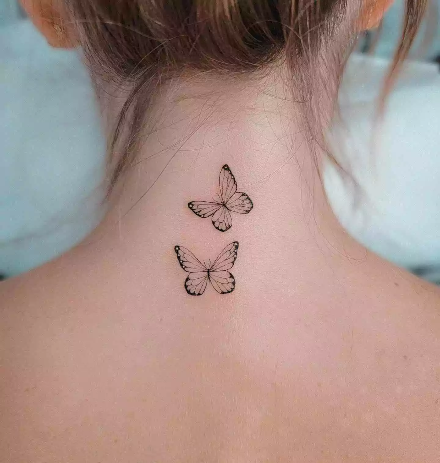 outline butterfly tattoo on nape