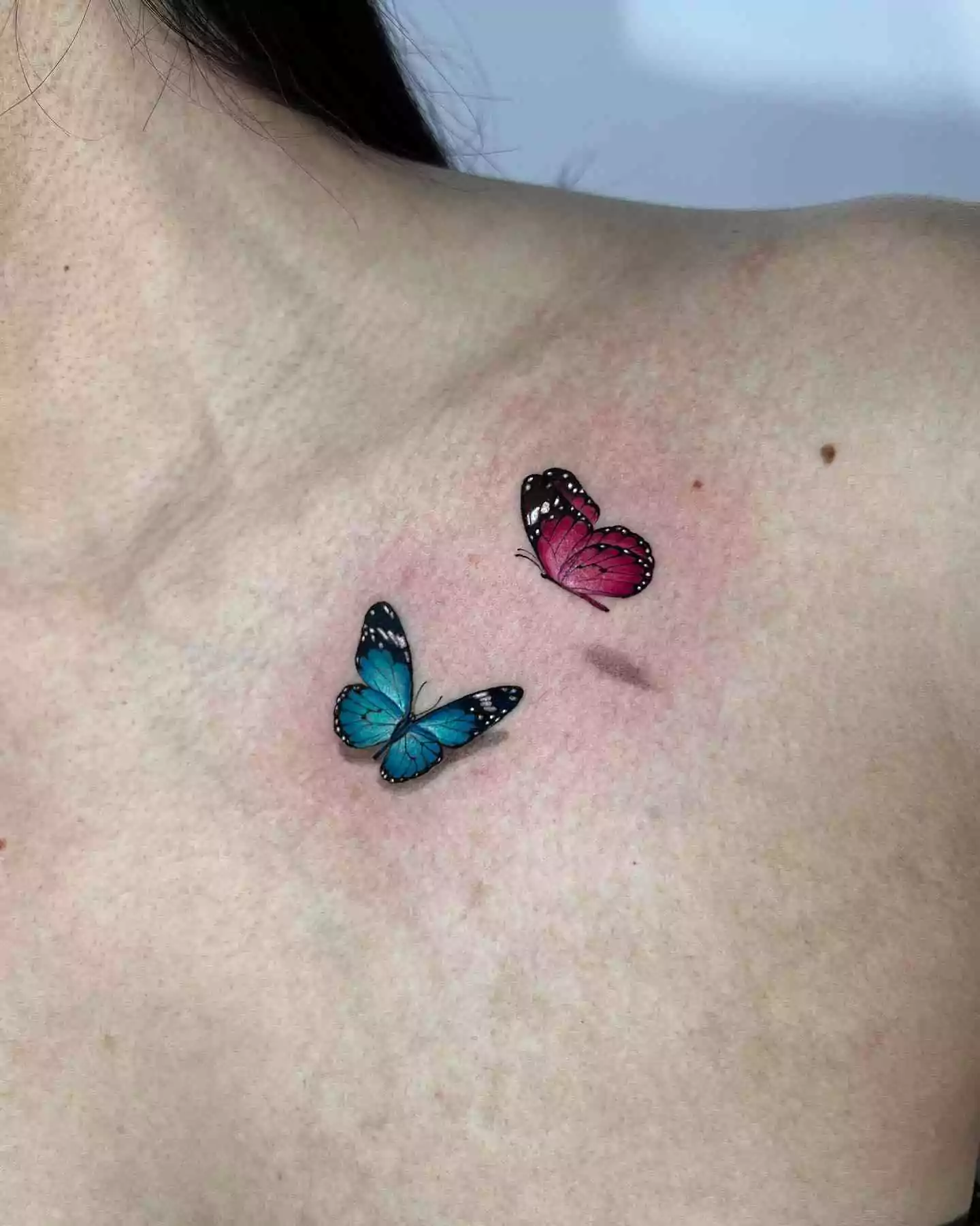 realistic butterfly tattoo on collarbone