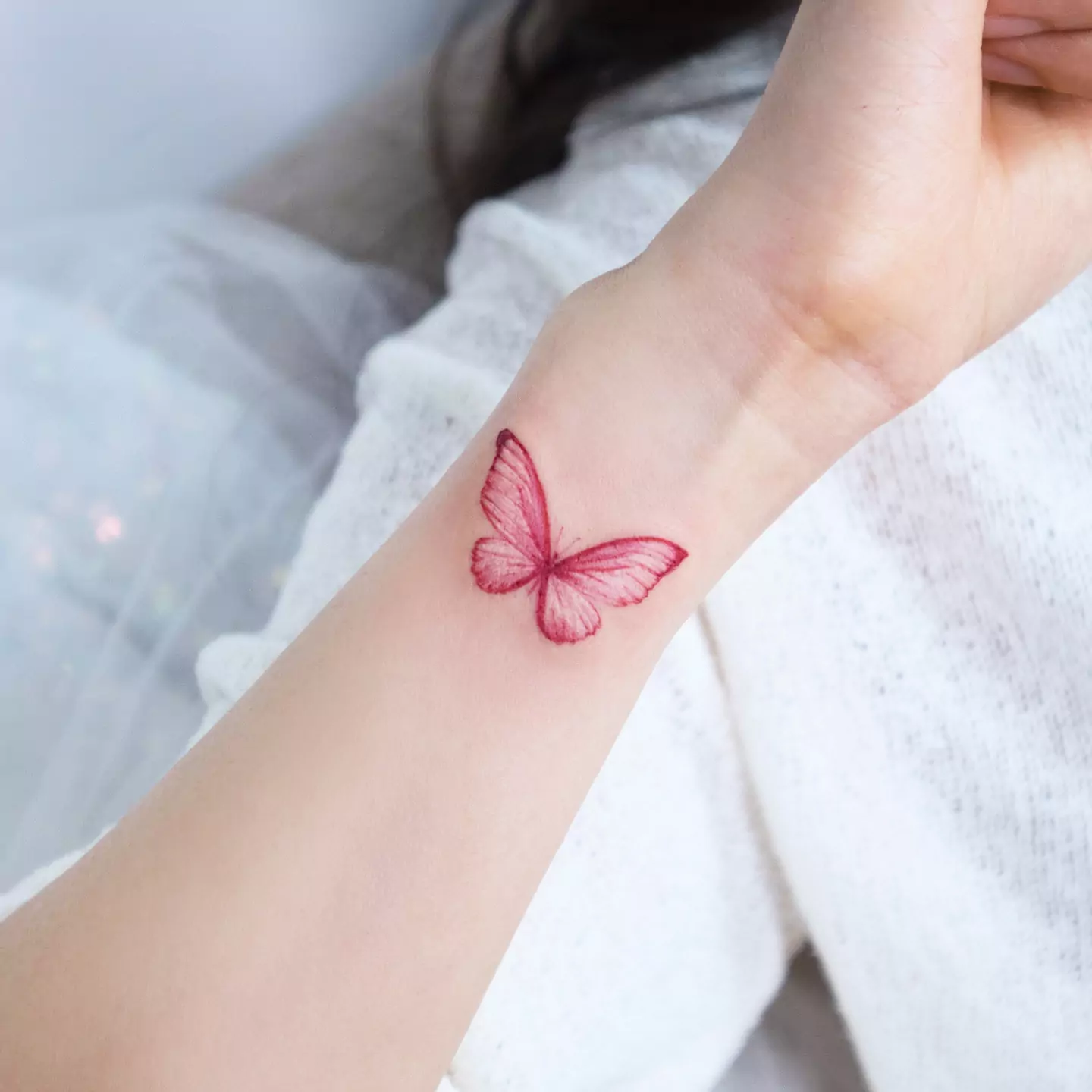 red butterfly tattoo on the wrist