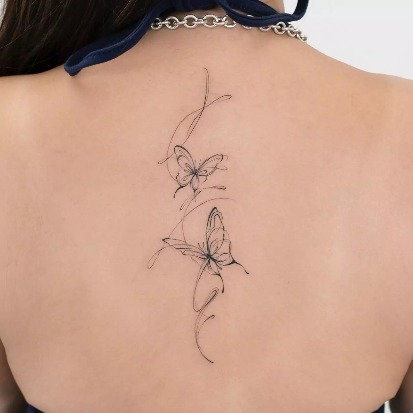 simple outline butterfly tattoo on back