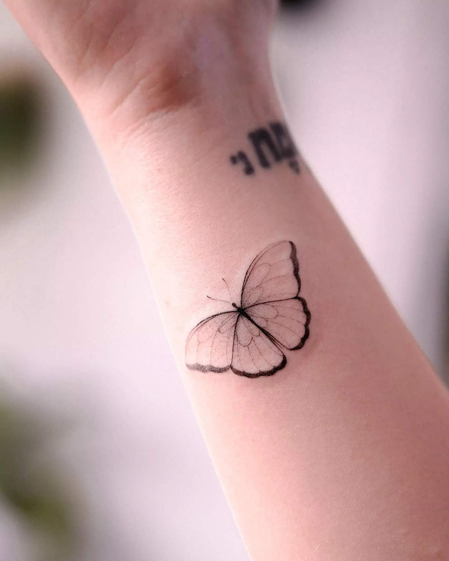 small black butterfly hand tattoo