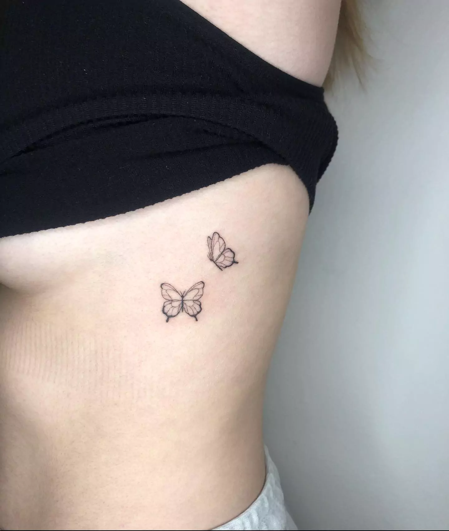 small butterflies tattoo on rib